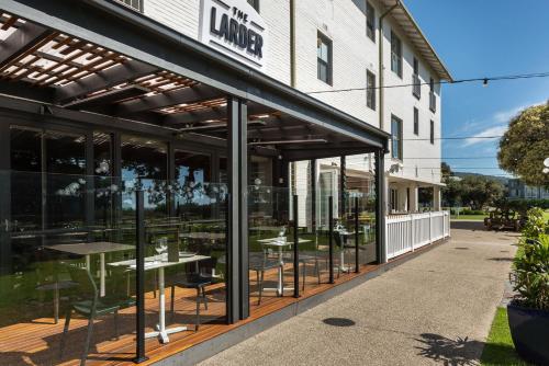 a restaurant with glass doors and tables in front of a building at Mantra Lorne in Lorne