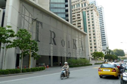 a person riding a motorcycle down a street next to a building at Exclusive The Troika Luxury Apartment in Kuala Lumpur