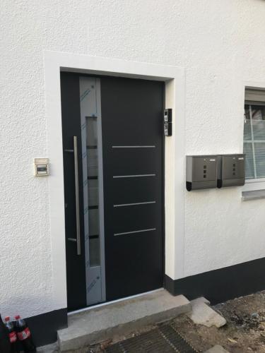 eine schwarze Tür an der Seite eines Gebäudes in der Unterkunft Wendlers Ferienwohnungen #1 #4 #5 #6 in Behringersdorf