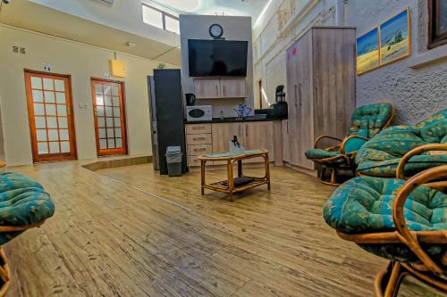 a living room with chairs and a tv and a table at A&A Guesthouse in Port Elizabeth