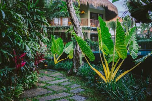 a garden filled with lots of plants next to a building at Honai Resort in Ubud