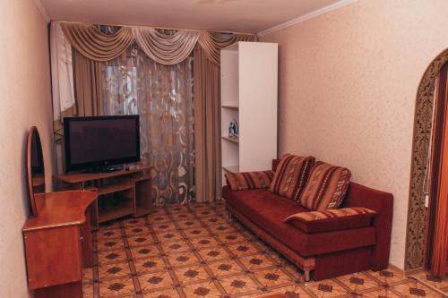 オムスクにあるApartment "Berloga 55" na Ordzhonikidzeのリビングルーム(ソファ、テレビ付)