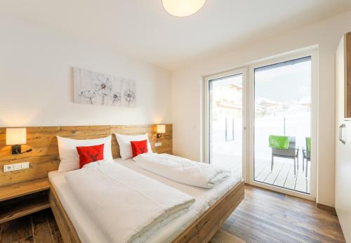 カプルーンにあるAurora Mountain Chalet by we rent, SUMMERCARD INCLUDEDのベッドルーム1室(大型ベッド1台、スライド式ガラスドア付)