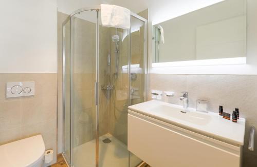 a bathroom with a shower and a sink and a toilet at Aurora Mountain Chalet by we rent, SUMMERCARD INCLUDED in Kaprun