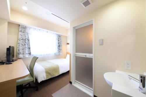 a hotel room with a bed and a window at Hotel Lifetree Hitachinoushiku in Ushiku