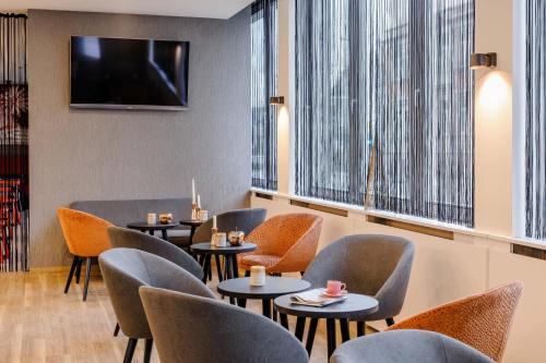 a restaurant with chairs and tables and a tv at ibis Styles Halle in Halle an der Saale