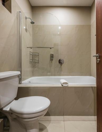 un baño con inodoro y bañera en Springbok Inn, en Springbok