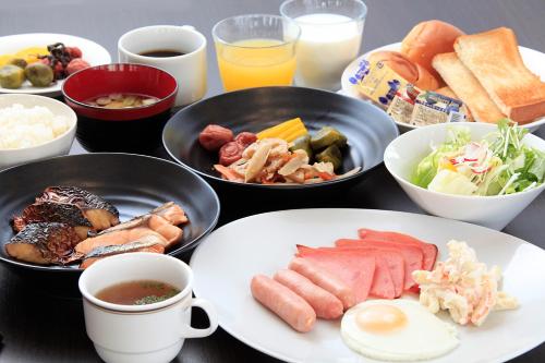 a table with plates of food and cups of coffee at Hotel Lifetree Hitachinoushiku in Ushiku