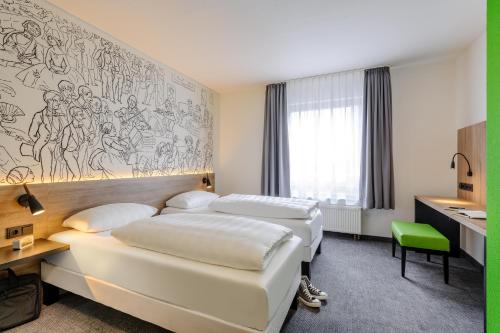 a hotel room with three beds and a desk at ibis Styles Halle in Halle an der Saale