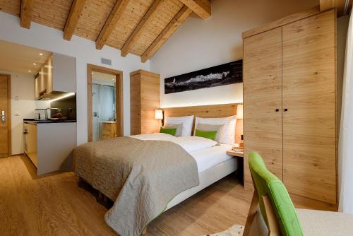 ein Schlafzimmer mit einem Bett und einem Schreibtisch in einem Zimmer in der Unterkunft EVA Serviced Apartments in Zermatt