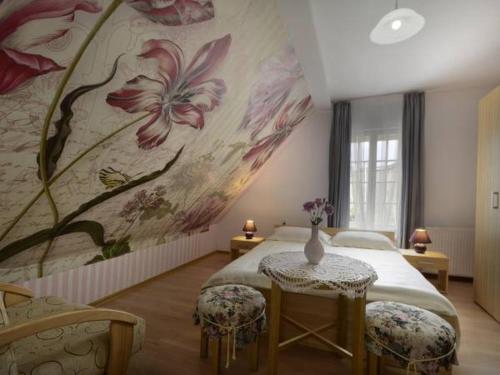 1 dormitorio con 1 cama con un mural de flores en la pared en Biały Dwór en Kostrzyca