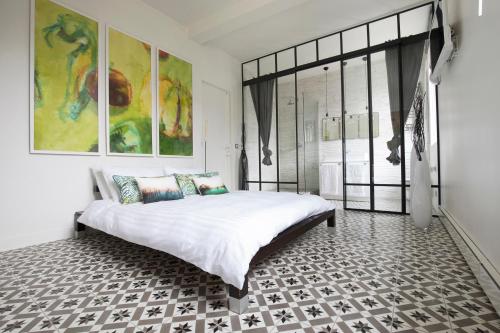ein Schlafzimmer mit einem großen Bett und einem großen Fenster in der Unterkunft MONTMARTRE ROMANTIC - chambres d'hôtes de charme à Montmartre - Paris in Paris