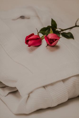 two roses sitting on top of a white pillow at Delta Sapa Hotel - Old Quarter Center in Sa Pa