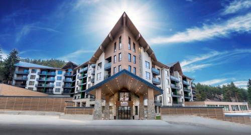 a large apartment building with a pointed roof at Hotel Arte SPA & Park in Velingrad