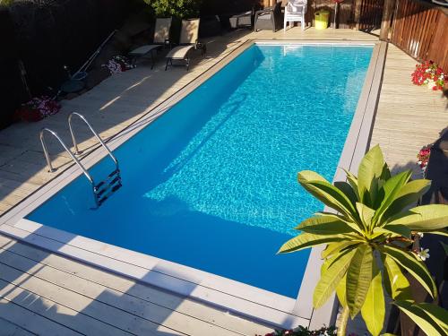 a swimming pool with blue water and a wooden deck at Volcanes in Had Nes