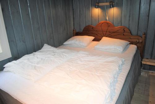 a large bed with white sheets and pillows at Grindaplassen in Leksvik