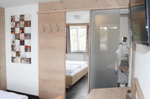 un miroir dans une chambre avec un lit et une chambre dans l'établissement Landhotel Schwarzer Adler, à Tiefenbronn
