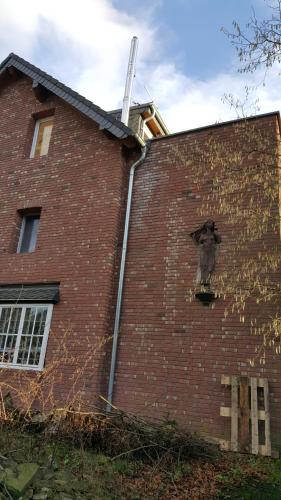 a brick building with a gargoyle on the side of it at villa high ceiling 2 bedrooms in Troisdorf