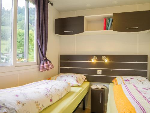 1 Schlafzimmer mit 2 Betten und einem Fenster in der Unterkunft Camping Boomerang in Poschiavo