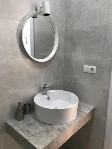 een badkamer met een witte wastafel en een spiegel bij Avlabari Apartment in Tbilisi City