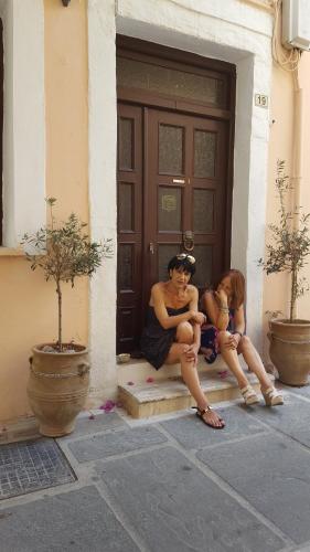 two women sitting on the steps of a door at Studio Lefaki in Rethymno Town
