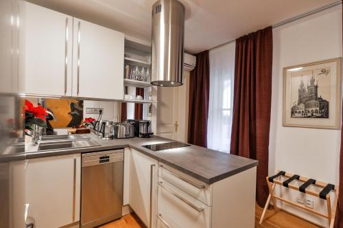 a kitchen with white cabinets and a sink at Romantic Apartment Prague near Charles Bridge in Prague