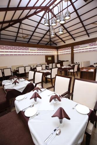 een eetkamer met witte tafels en stoelen bij The Ocean Pearl Resort And Spa in Hubli