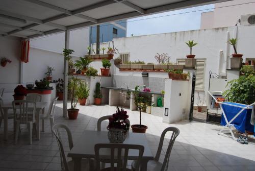 a patio with tables and chairs and potted plants at Baia Unci in Canneto