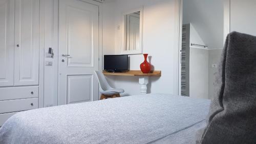 Schlafzimmer mit einem Bett und einem Schreibtisch mit einem TV in der Unterkunft Allegro Luxury B&B in Rocca di Papa