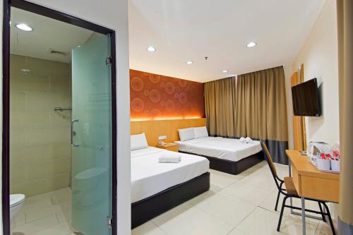 Habitación de hotel con 2 camas y ducha en Signature Hotel @ Puchong Setiawalk en Puchong