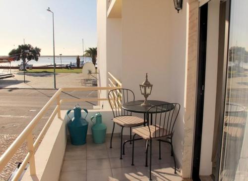 a table and chairs on a balcony with a view of the ocean at Casa Esti in Olhão