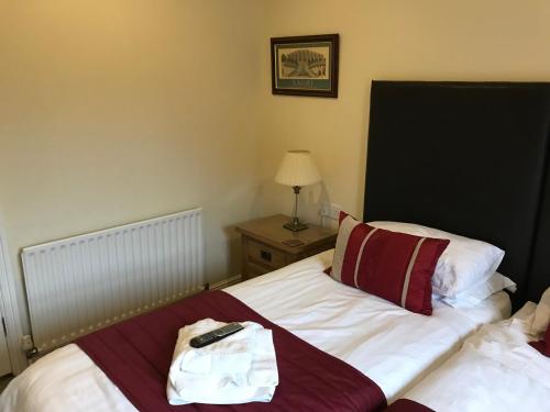 a bedroom with a bed with a remote control on it at Clayhanger Guest House in Newcastle under Lyme