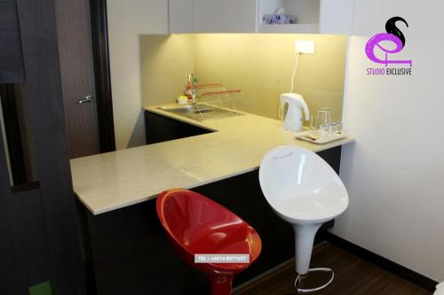 a kitchen with a red chair and a sink at Studio Exclusive (Kota Bharu City Point) in Kota Bharu