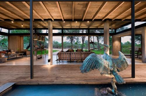a house with a bird statue in the middle of a porch at Lion Sands Ivory Lodge in Sabi Sand Game Reserve