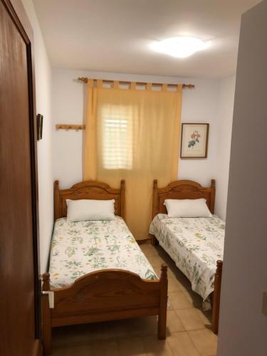 ロス・カンカホスにあるSan Antonino del Marのベッドルーム1室(ベッド2台、窓付)