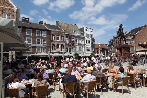 a crowd of people sitting at tables in a street at Liry's Home in Tongeren