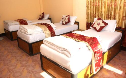 a group of four beds in a room at Elbrus Home in Kathmandu