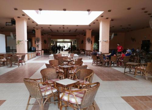 a restaurant with tables and chairs and people sitting at tables at Palmera El Sokhna Chalets Families Only in Ain Sokhna