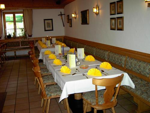 a row of tables in a restaurant with yellow napkins at Gasthaus zur Moosmühle in Huglfing