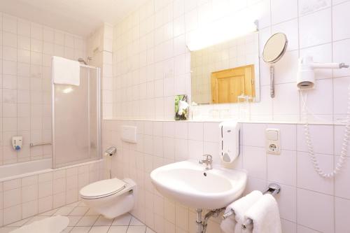 a white bathroom with a sink and a toilet at Gasthaus zur Moosmühle in Huglfing