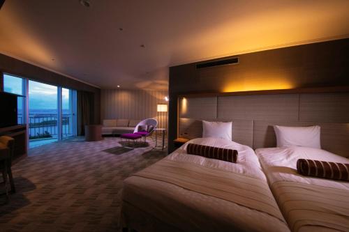 a hotel room with two beds and a television at Laguna Garden Hotel in Ginowan
