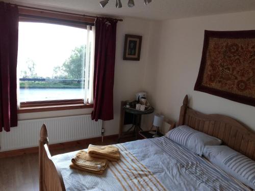 a bedroom with a bed and a large window at Pammy's Family Annexe EXCLUSIVE USE in Garve
