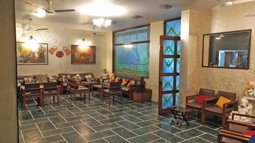 a waiting room with tables and chairs in a building at Hotel Rangoli in Jaipur