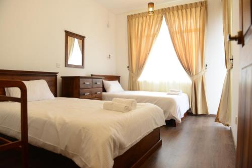 a hotel room with two beds and a window at City Square Residencies in Colombo