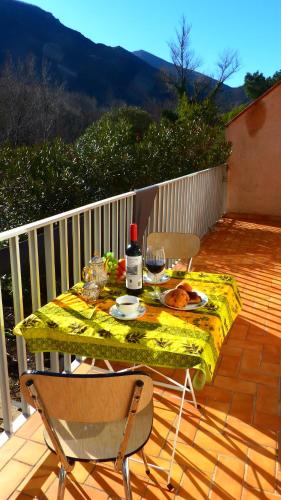 - une table avec une assiette de nourriture et une bouteille de vin dans l'établissement Eole, à Amélie-les-Bains-Palalda