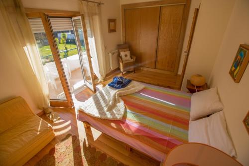 ナザレにあるYour Nest in Nazaré - Ocean View Villaのベッド1台(レインボーブランケット付)