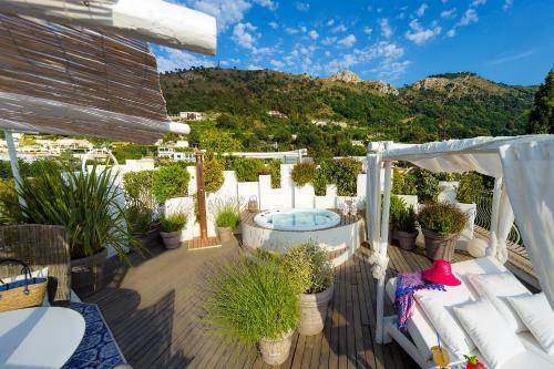 a deck with a hot tub and potted plants at Hotel Villa Blu Capri in Anacapri