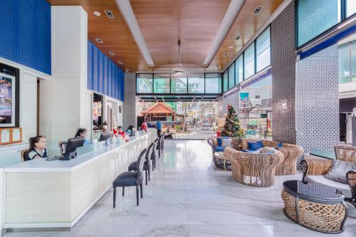 a lobby with people sitting at a counter in a mall at The Beach Heights Resort SHA Plus in Kata Beach
