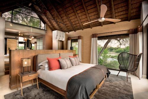 een slaapkamer met een groot bed en een plafondventilator bij Lion Sands Ivory Lodge in Sabi Sand Game Reserve