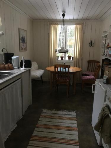 uma cozinha e sala de jantar com mesa e cadeiras em Lillemyrsgården em Forshaga